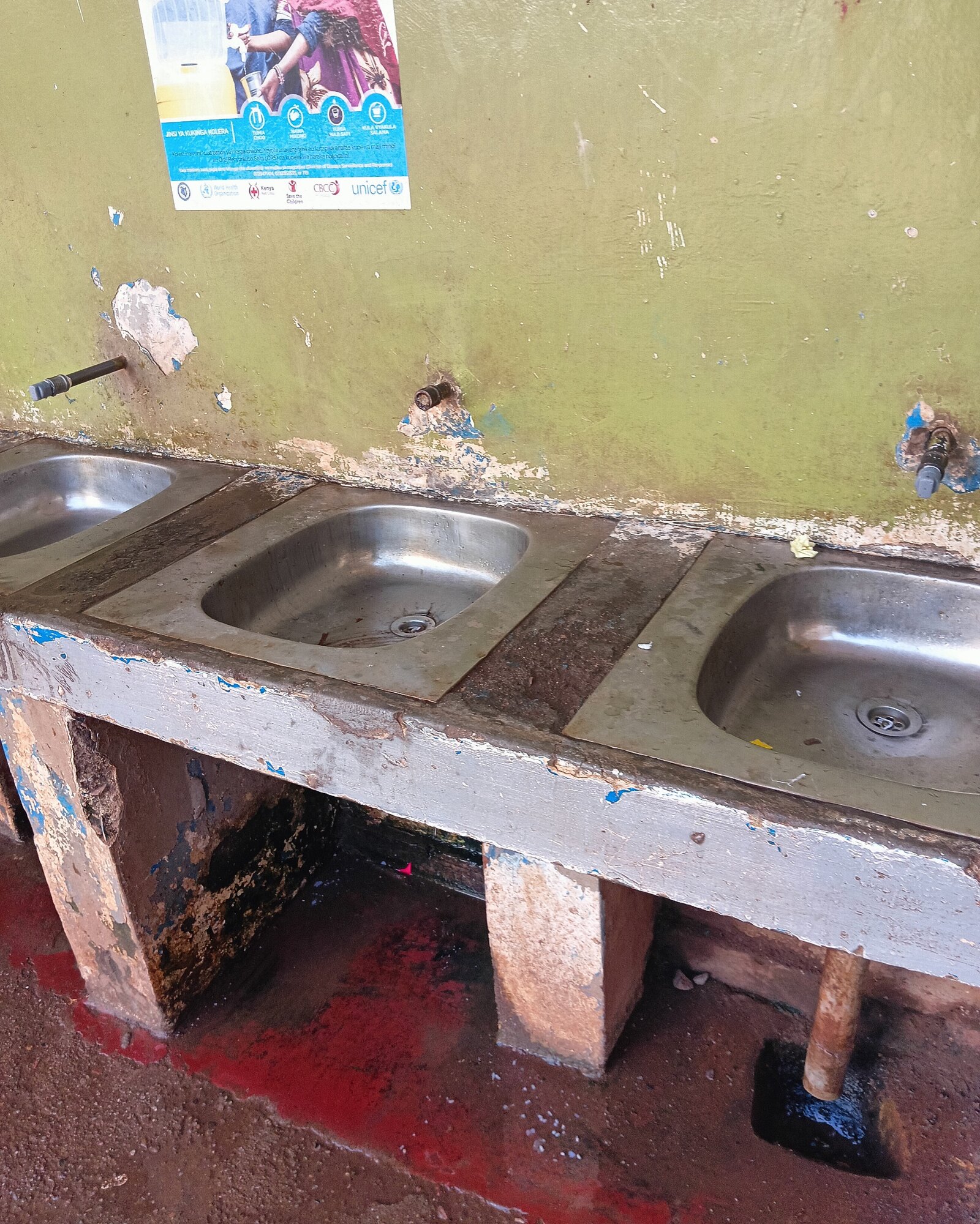 Public school handwashing sinks with conventional taps broken off or removed at the wall.