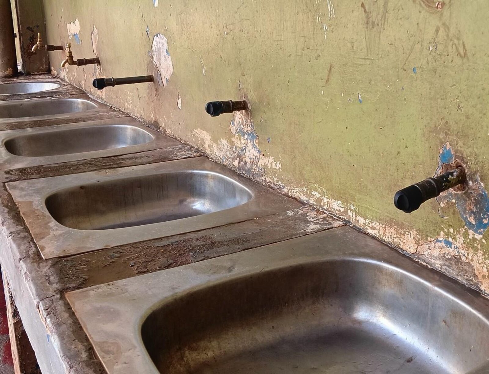 Durable Tap prototypes installed along a run of school handwashing sinks during field trials.